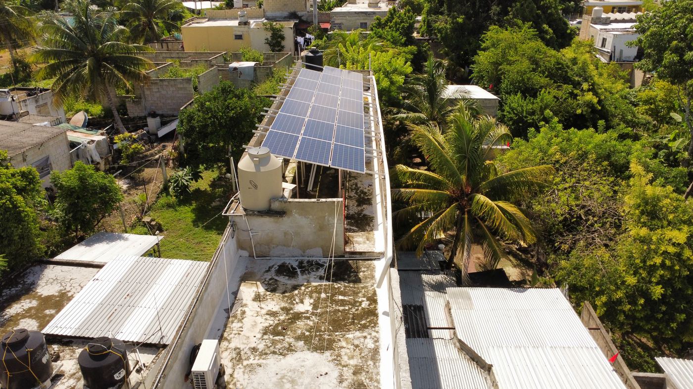 Vista aérea de sistema fotovoltaico sobre techo elevado con estructura